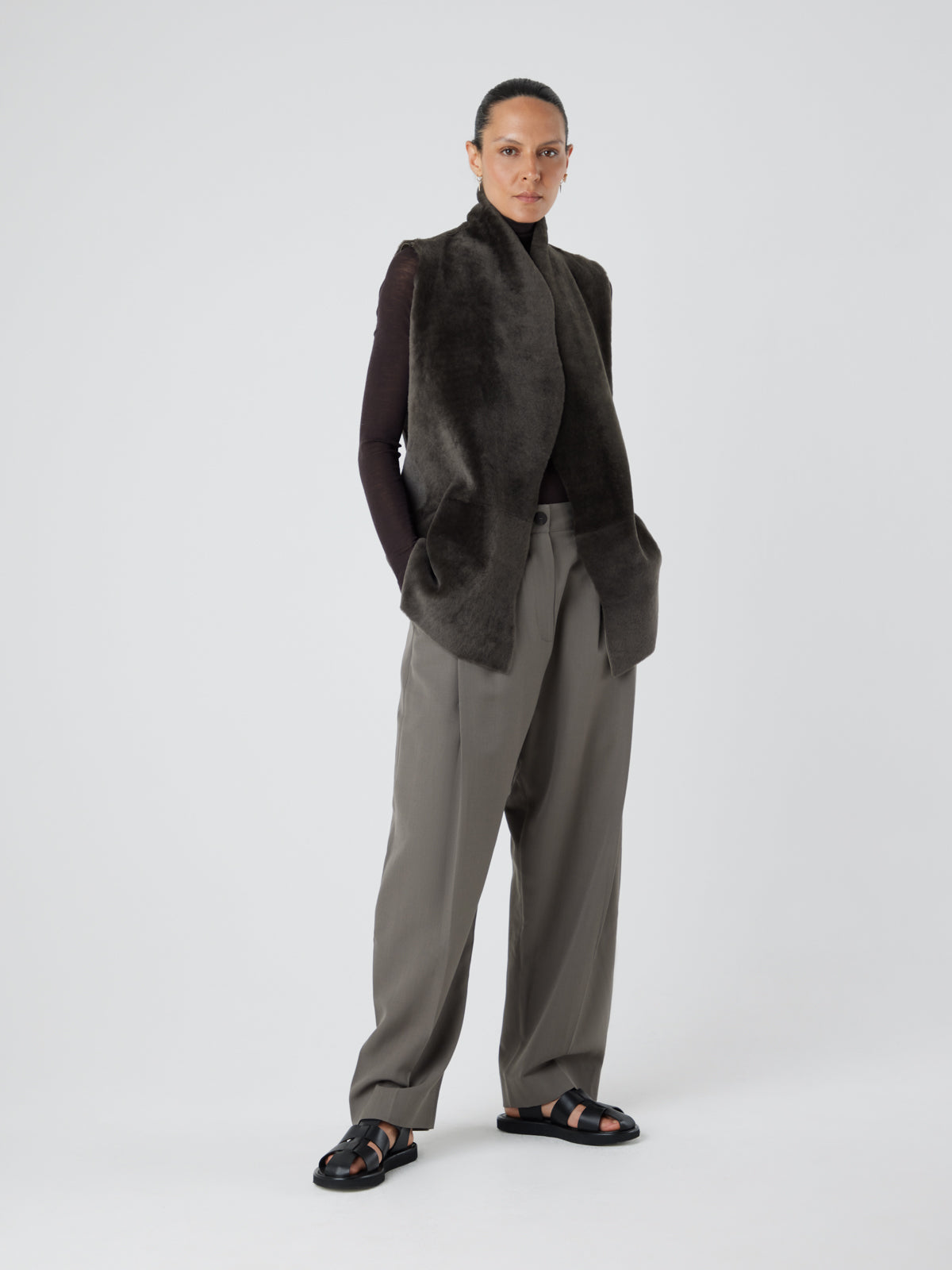 Natural Edge Storm Green Mid Length Shearling Gilet - model full length wool out hands in pockets