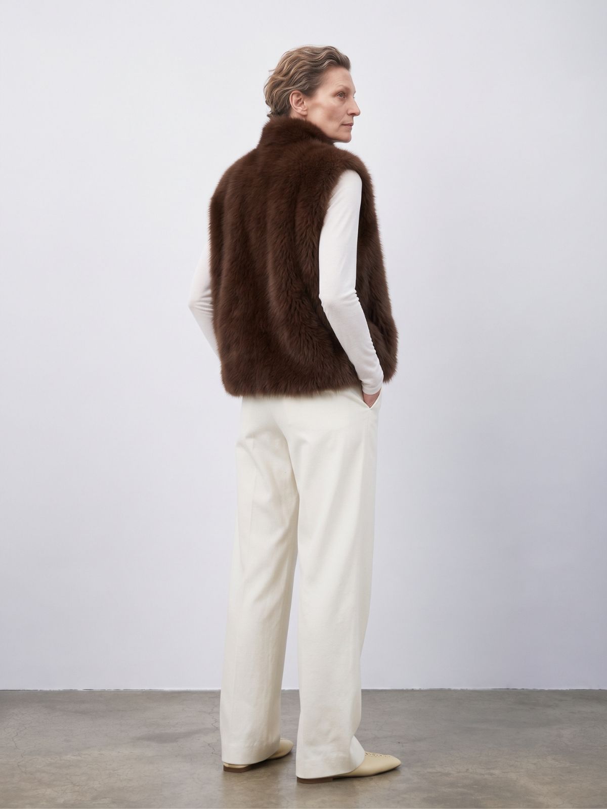 back view of woman wearing natural edge brown shearling gilet by gushlow & cole