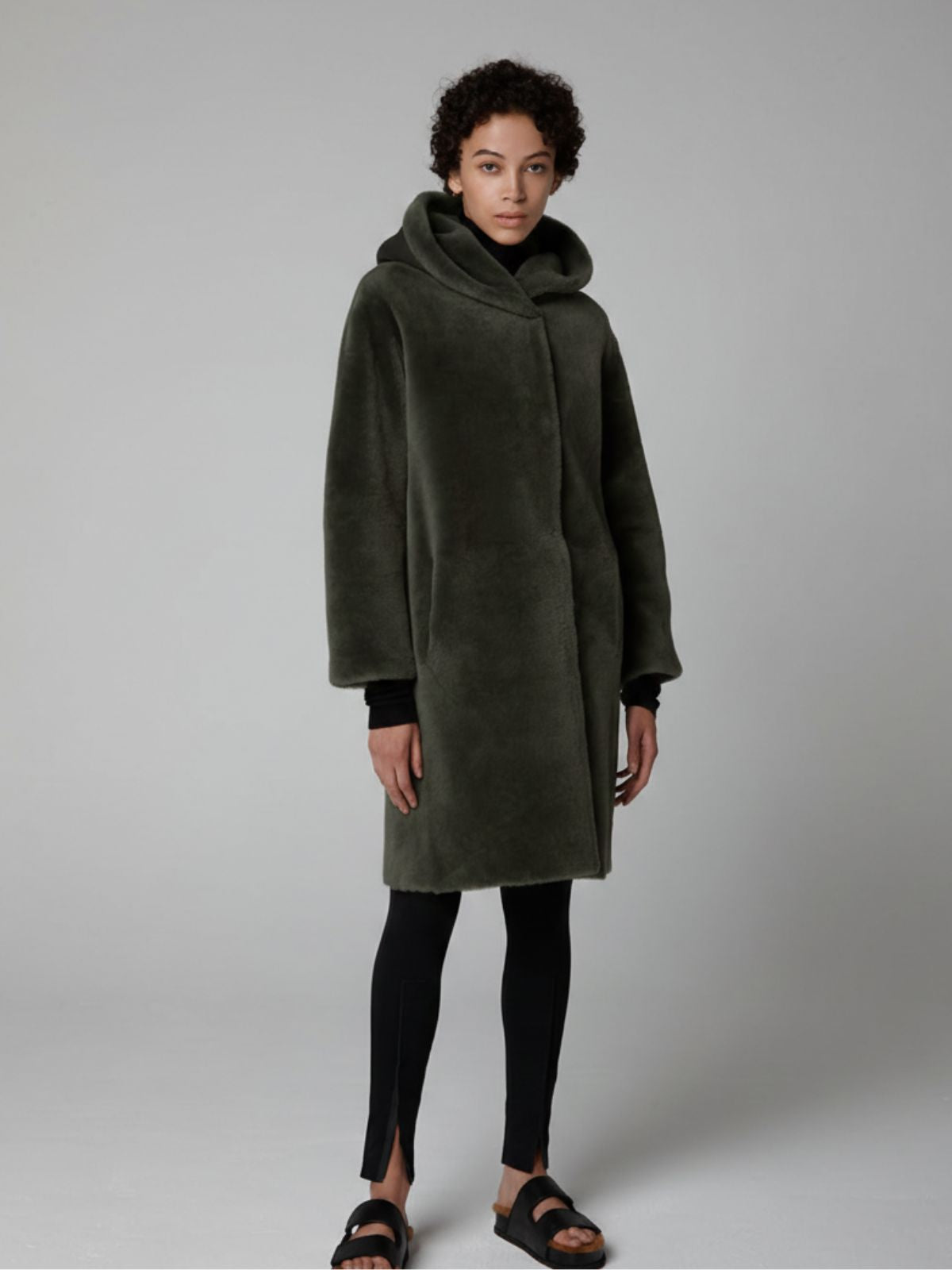 women wearing Storm Green Hooded Shearling Coat by Gushlow & Cole on grey background
