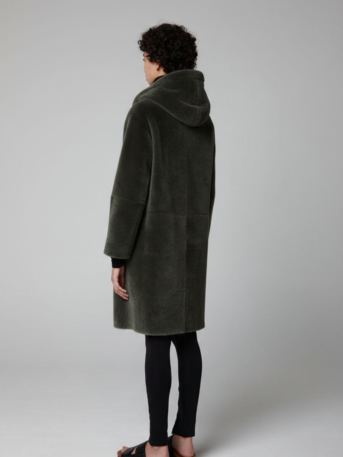 back of women wearing Storm Green Hooded Shearling Coat by Gushlow & Cole on grey background