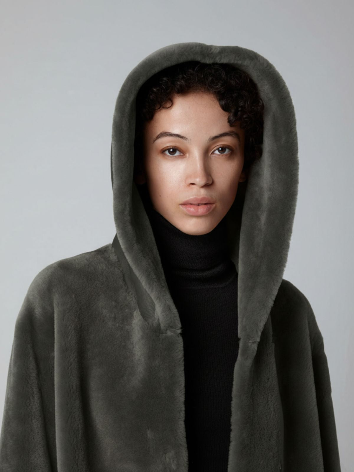 crop in of women wearing Storm Green Hooded Shearling Coat by Gushlow & Cole on grey background