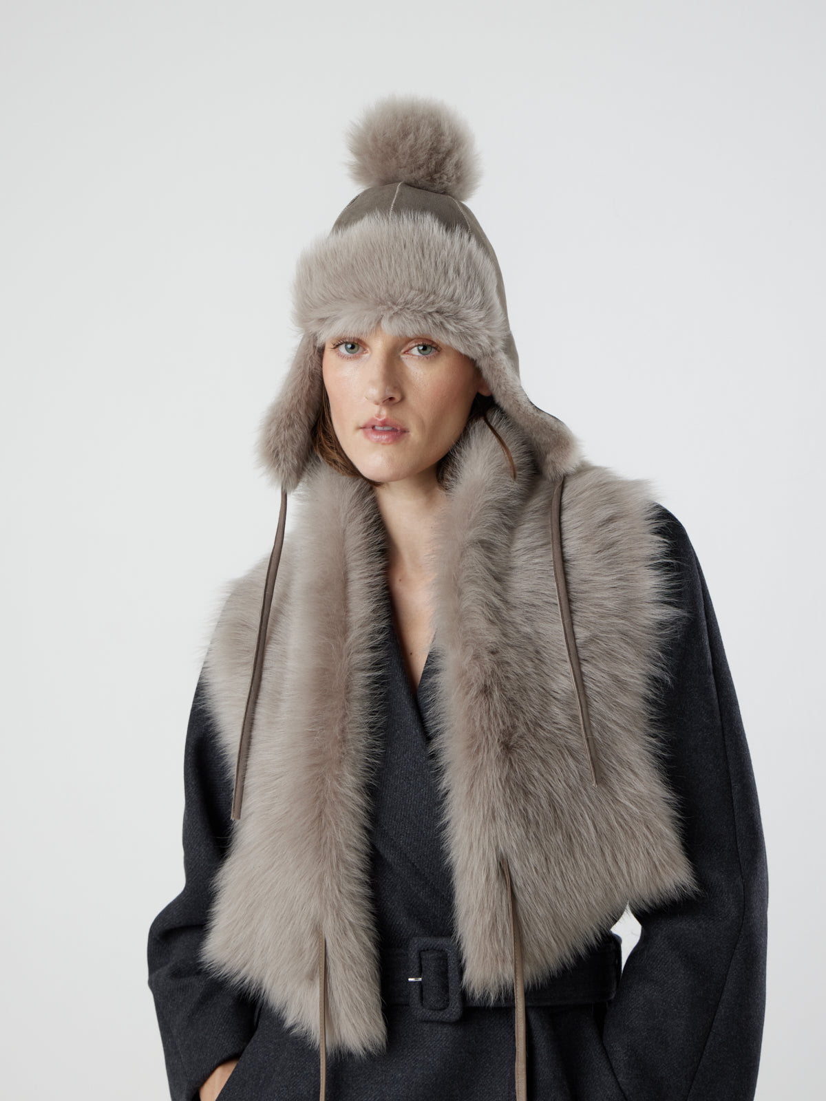 woman wearing taupe Shearling Shawl Scarf with nappa leather ties and taupe toscana shearling beanie by gushlow & cole on white background