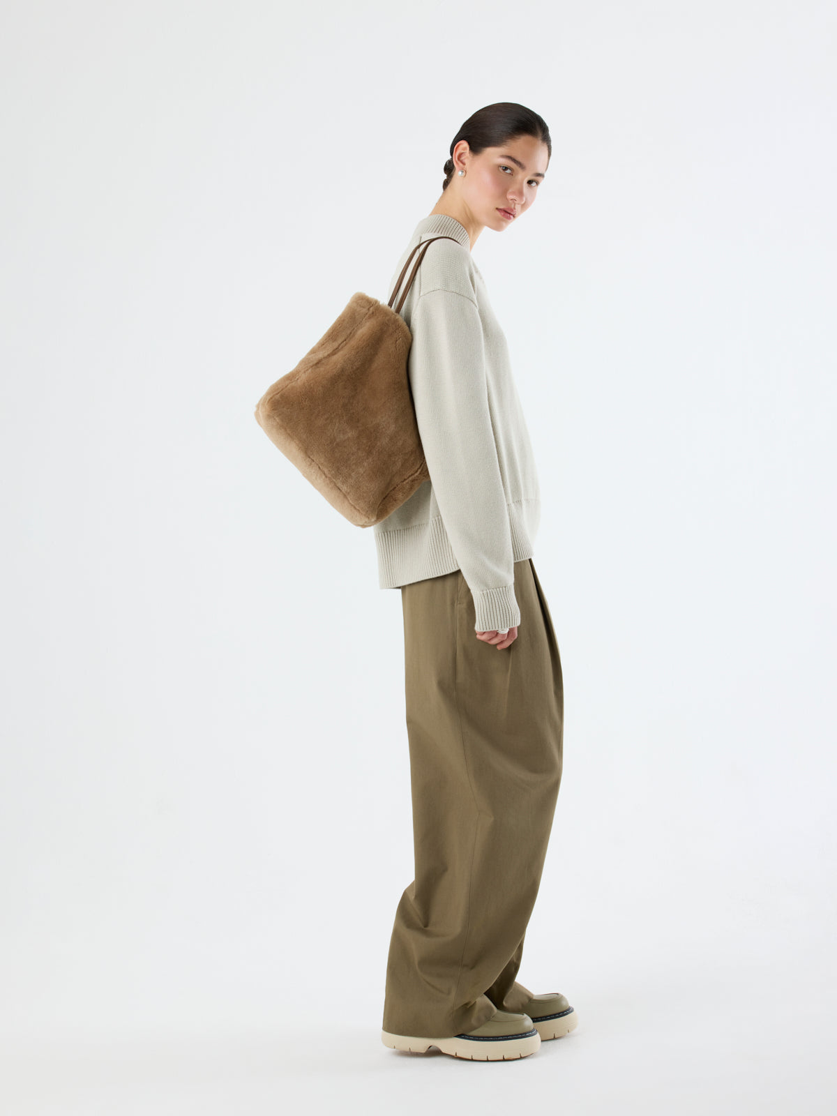 woman holding Tory Camel Shearling Tote Bag by gushlow & cole over shoulder