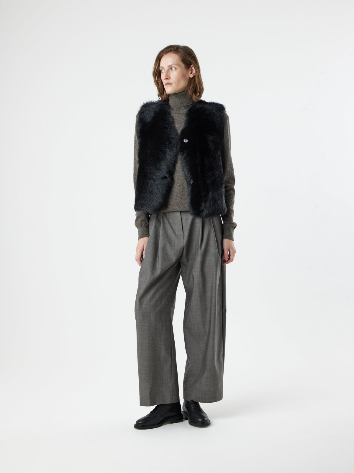 woman wearing Two Button Black Shearling Vest by gushlow & cole on white background 
