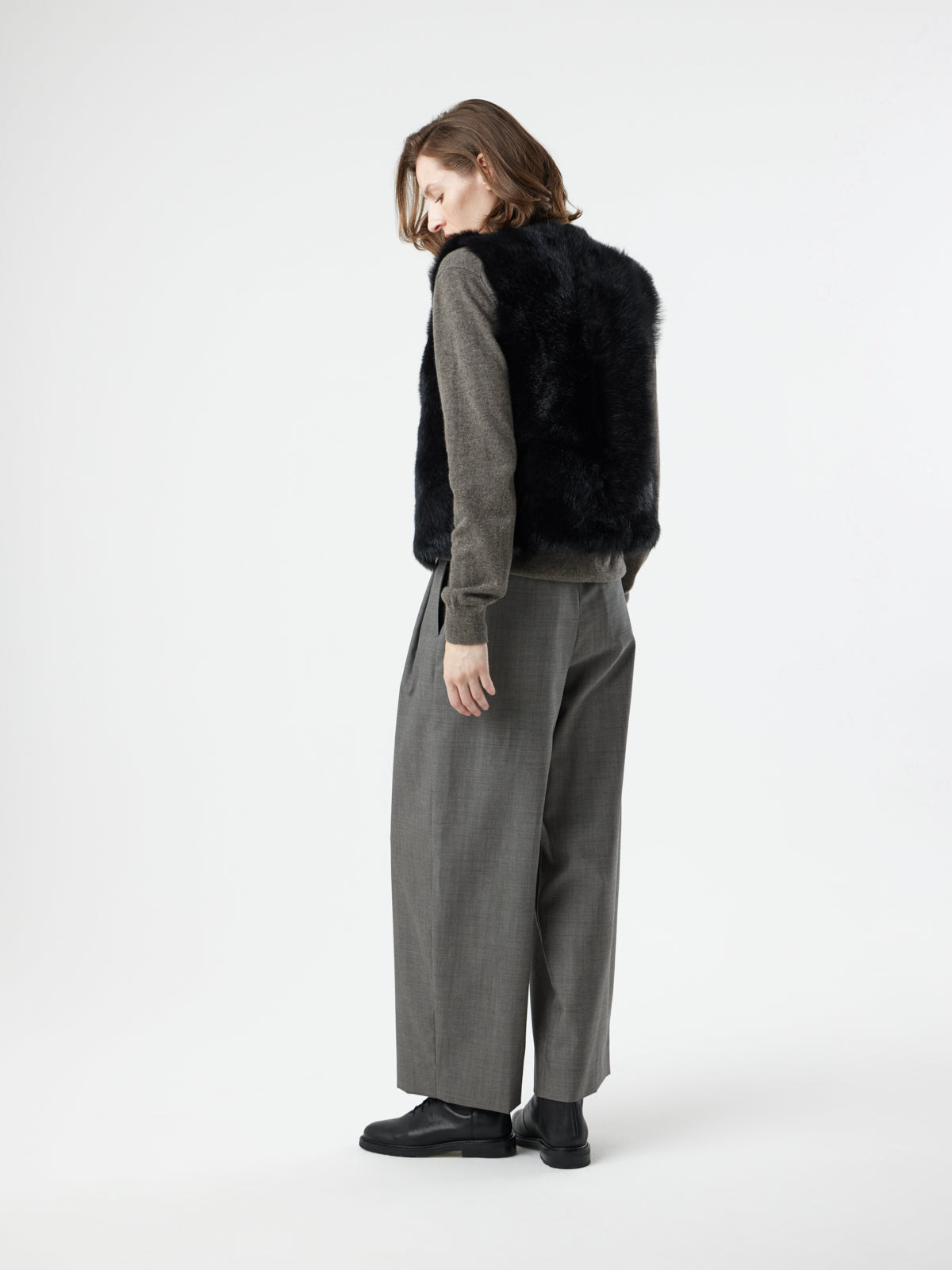 back view of woman wearing Two Button Black Shearling Vest by gushlow & cole on white background 