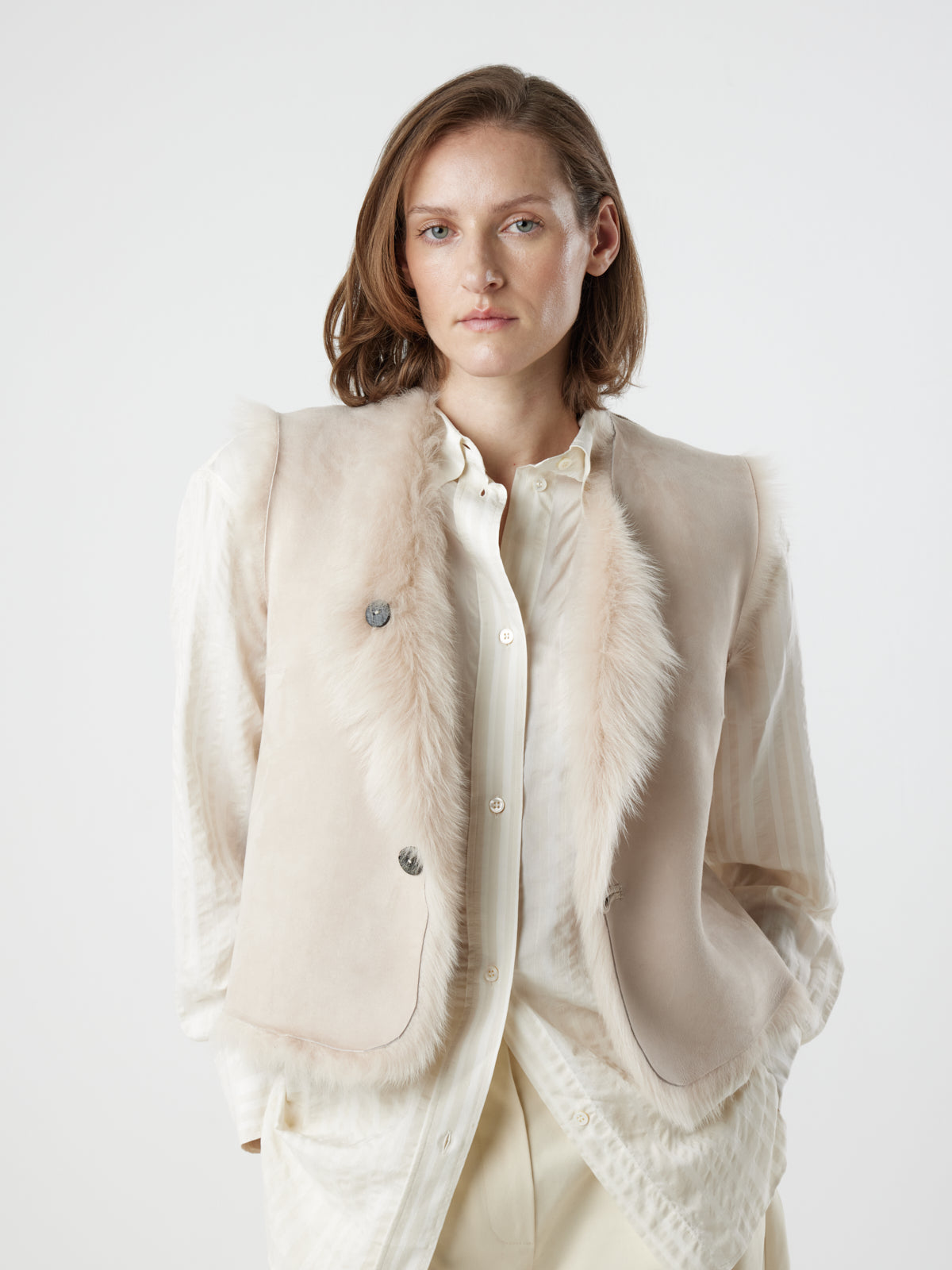 woman wearing reversed Two Button Cream Shearling Vest by gushlow & cole on white background