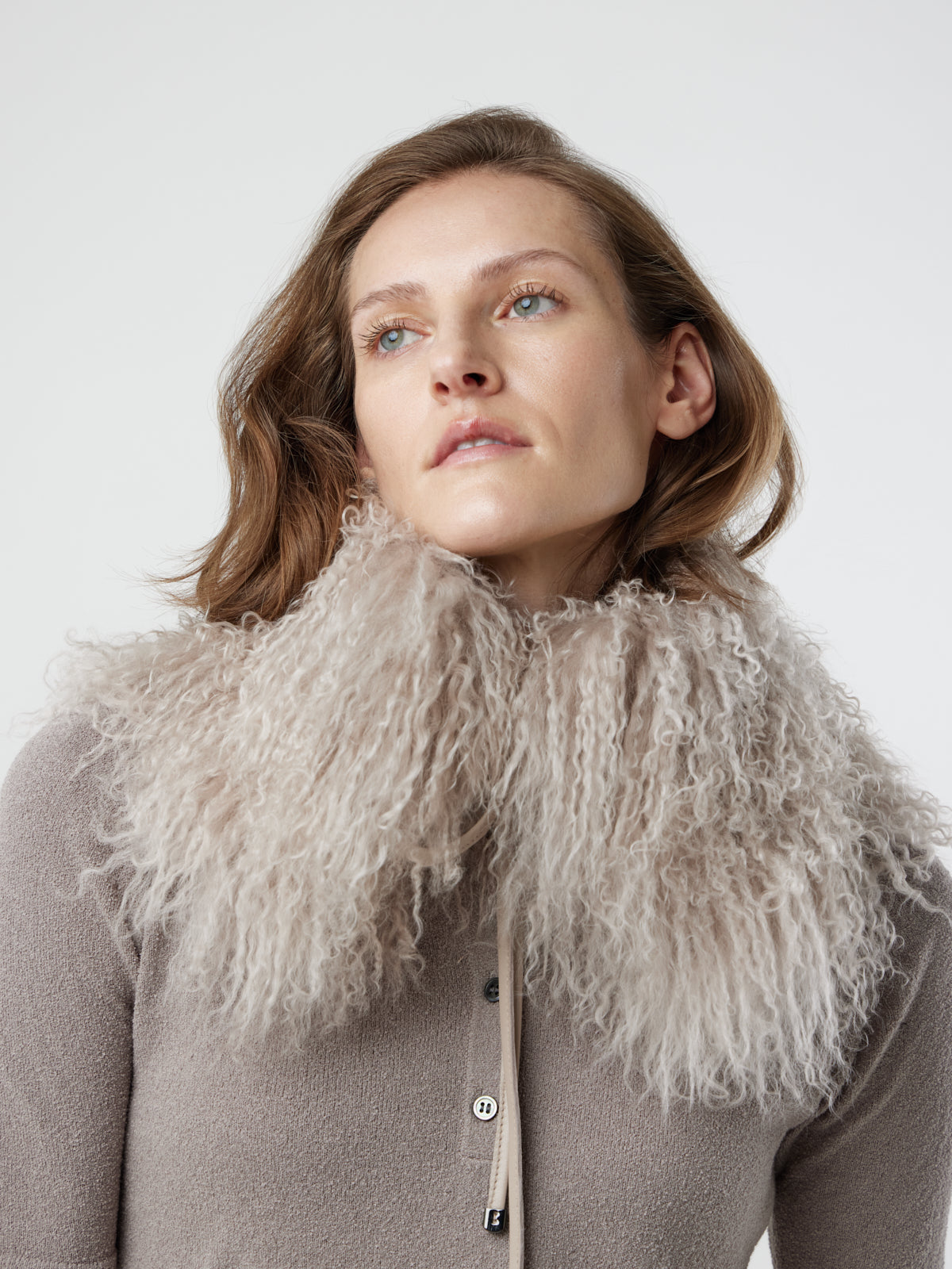 Woman wearing White Mongolian Shearling Collar Scarf over jumper by gushlow & cole