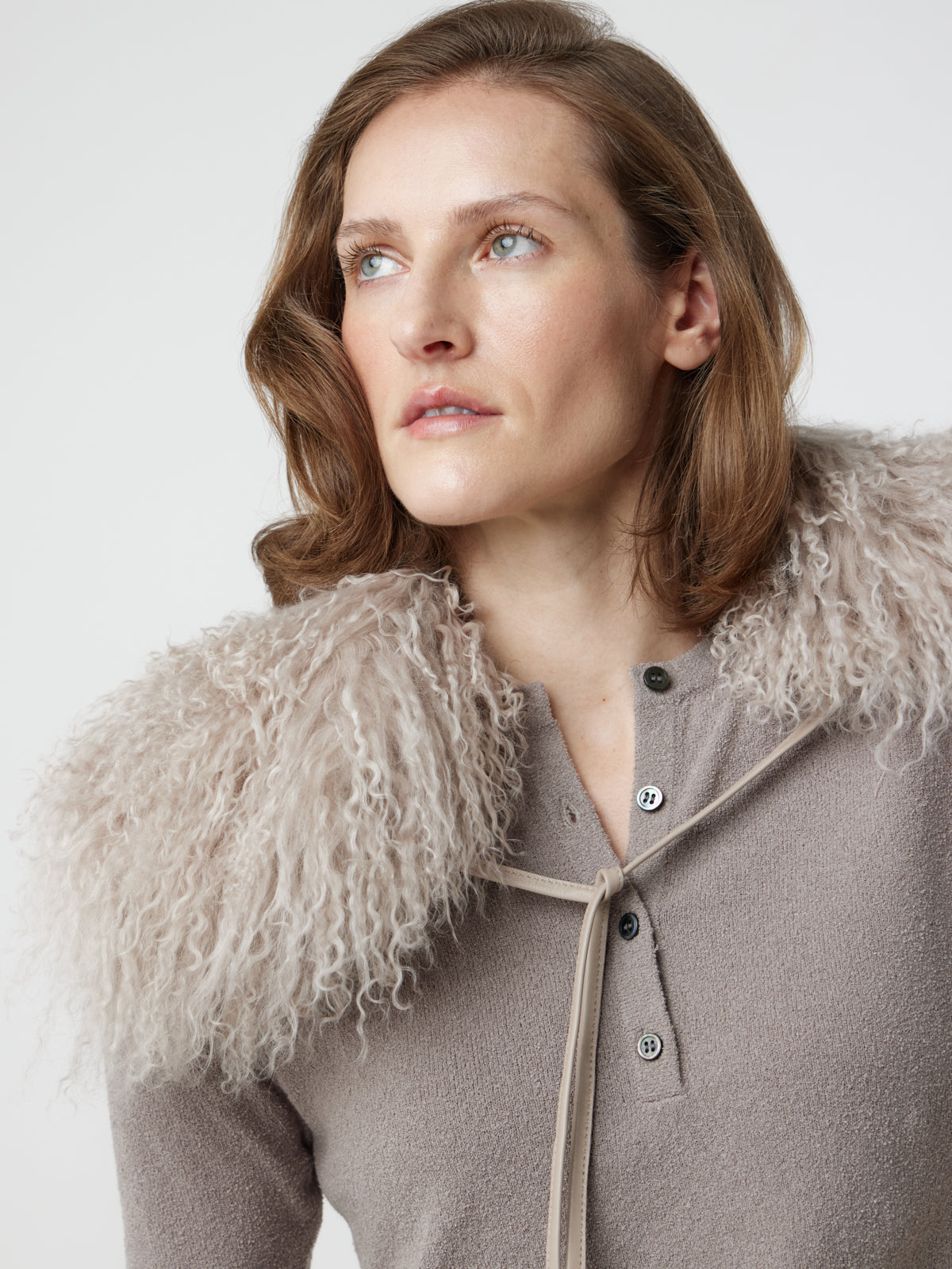 Woman wearing White Mongolian Shearling Collar Scarf tied at front by gushlow & cole