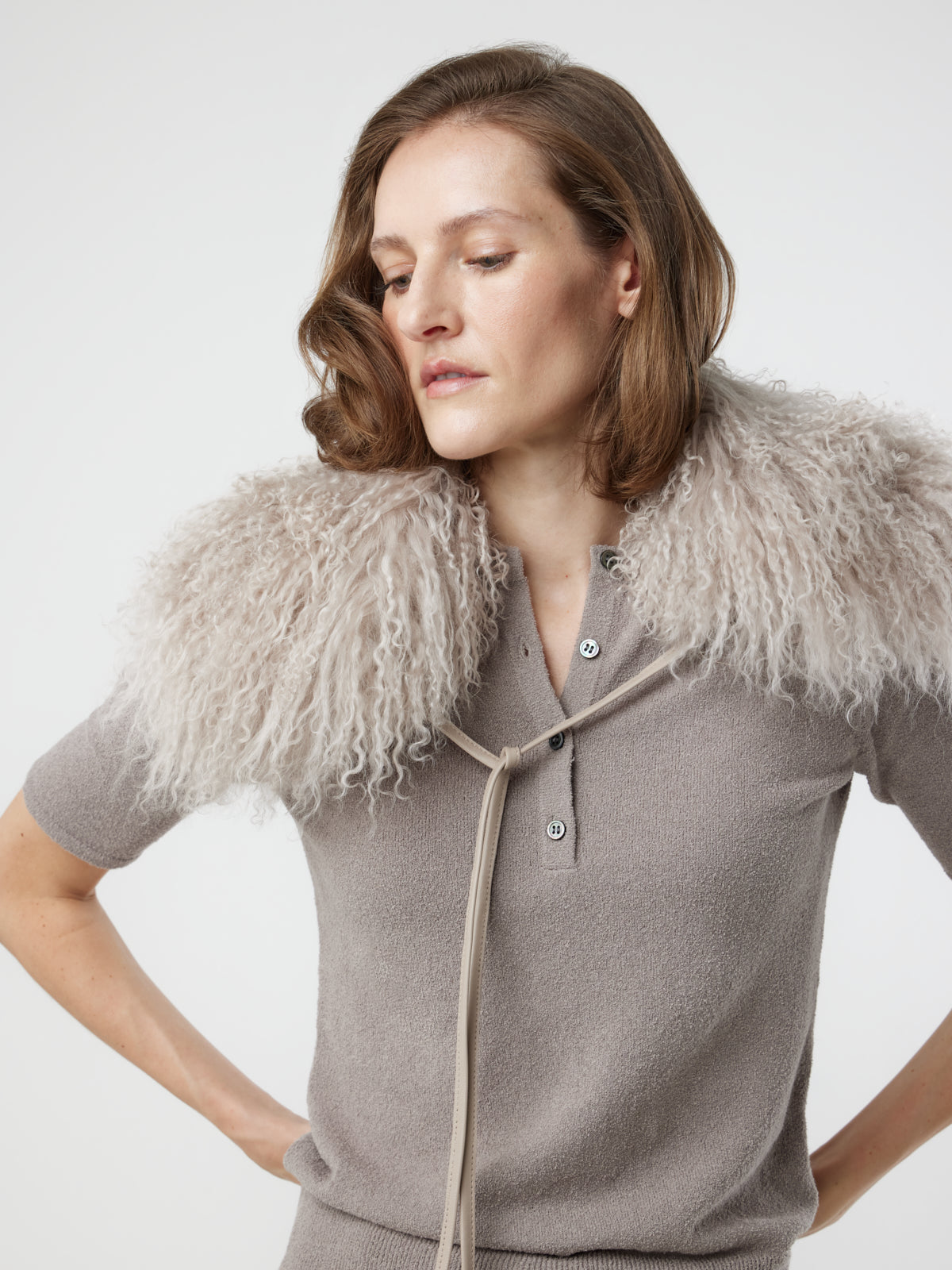 Woman with hands on hips wearing White Mongolian Shearling Collar Scarf over jumper by gushlow & cole