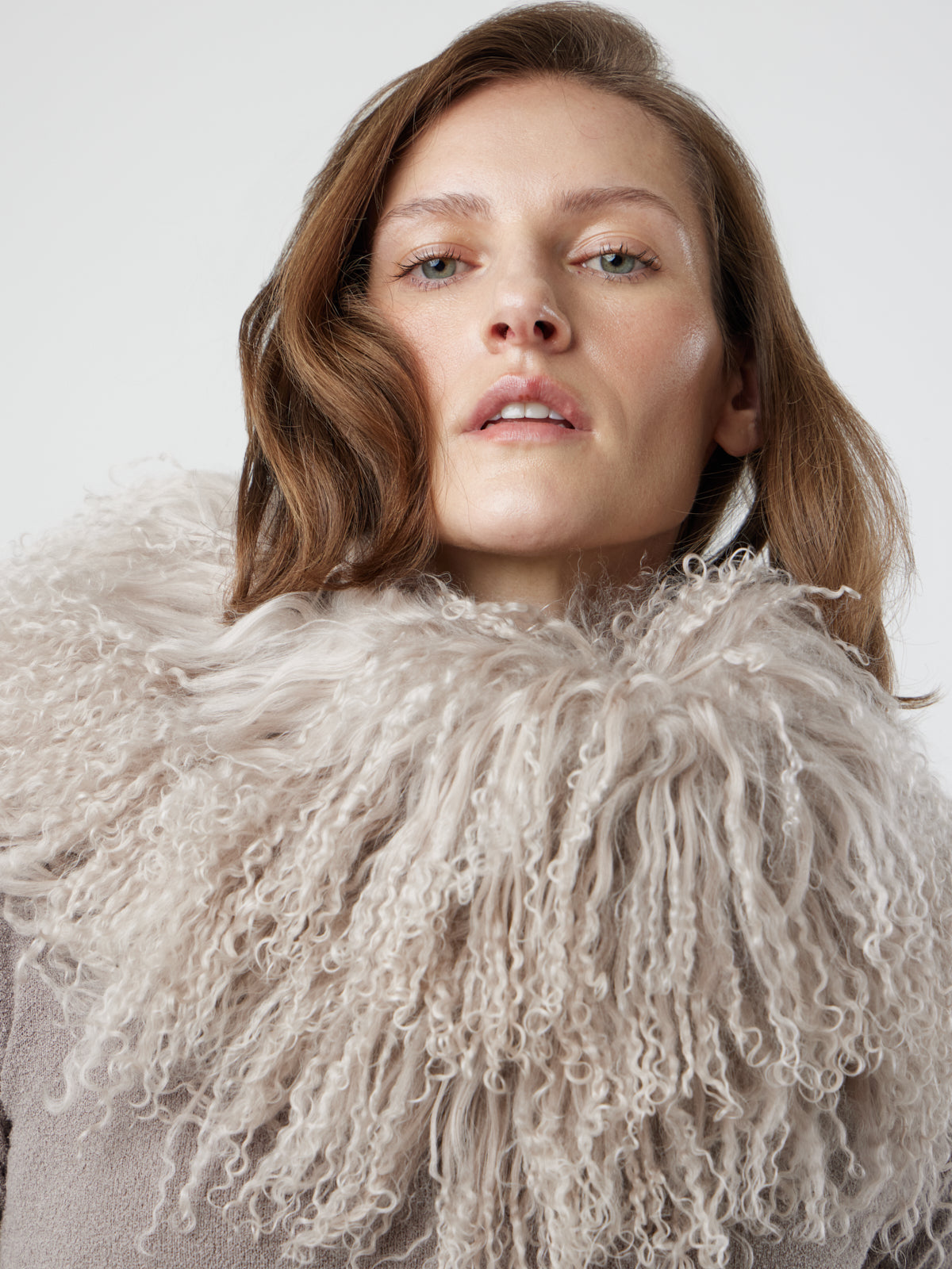 Woman wearing White Mongolian Shearling Collar Scarf over jumper by gushlow & cole