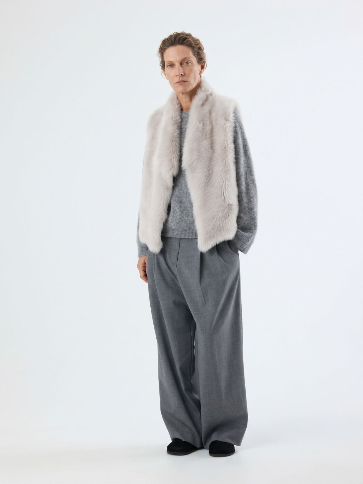 woman wearing white shearling and hand knit gilet by gushlow & cole