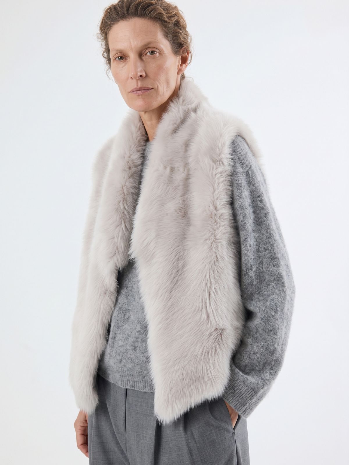 woman wearing white shearling and hand knit gilet by gushlow & cole
