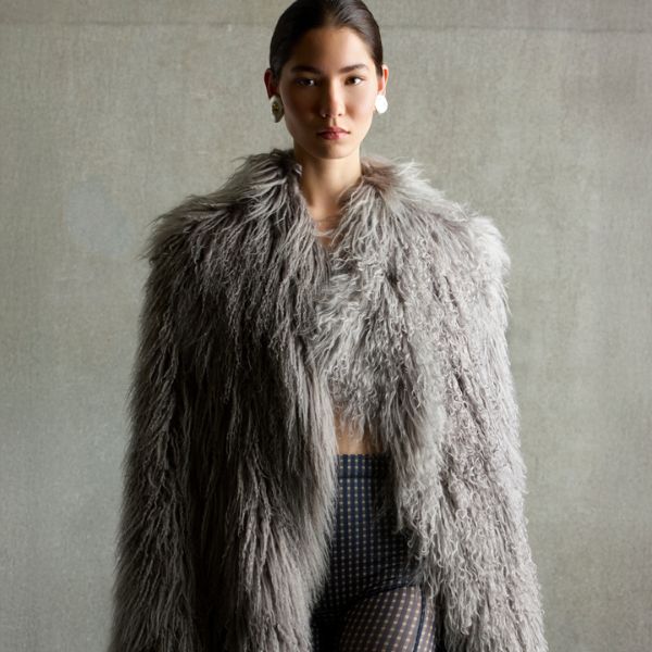 woman wearing long grey mongolian shearling coat on grey background - luxury womens shearling gushlow & cole