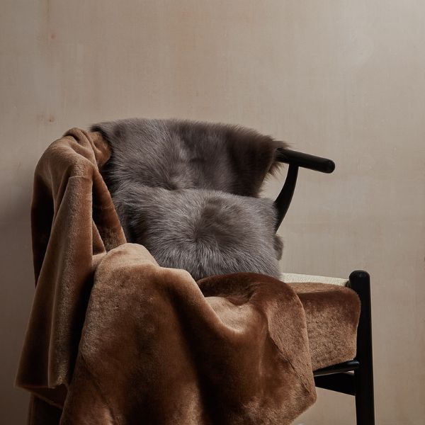 shearling throw and shearling cushion on chair - luxury shearling homeware gushlow & cole
