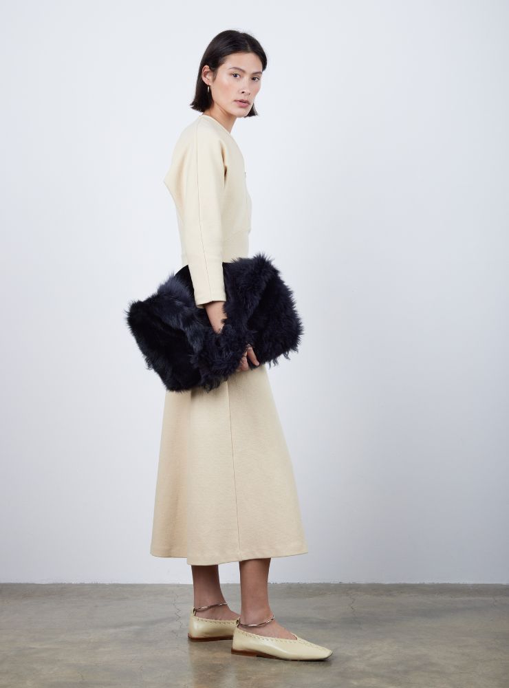 woman wearing large black shearling shoulder bag on white background - luxury womens shearling gushlow & cole - no fur 