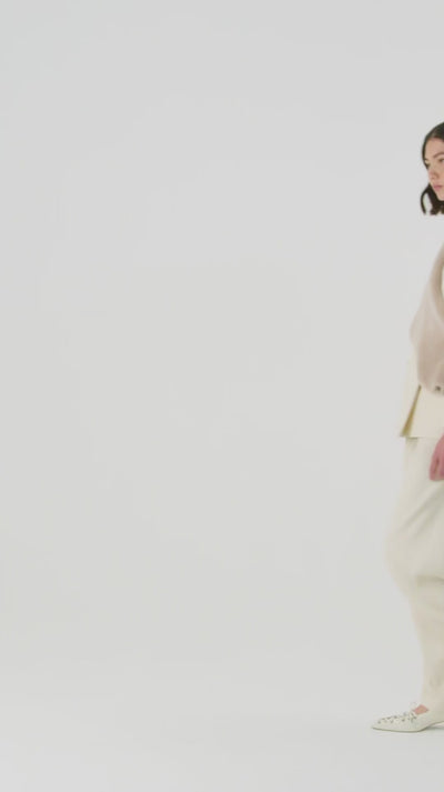 woman wearing cream merino shawl scarf by gushlow & cole over cream matching two piece suit on white background