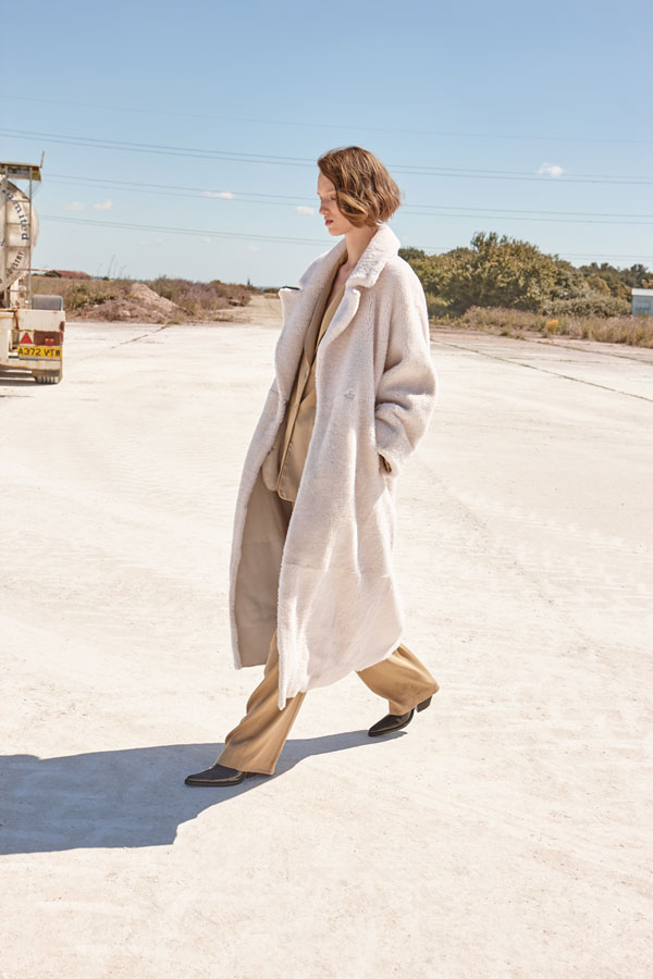 white shearling trench coat in white - women | gushlow and cole - model walking in coat